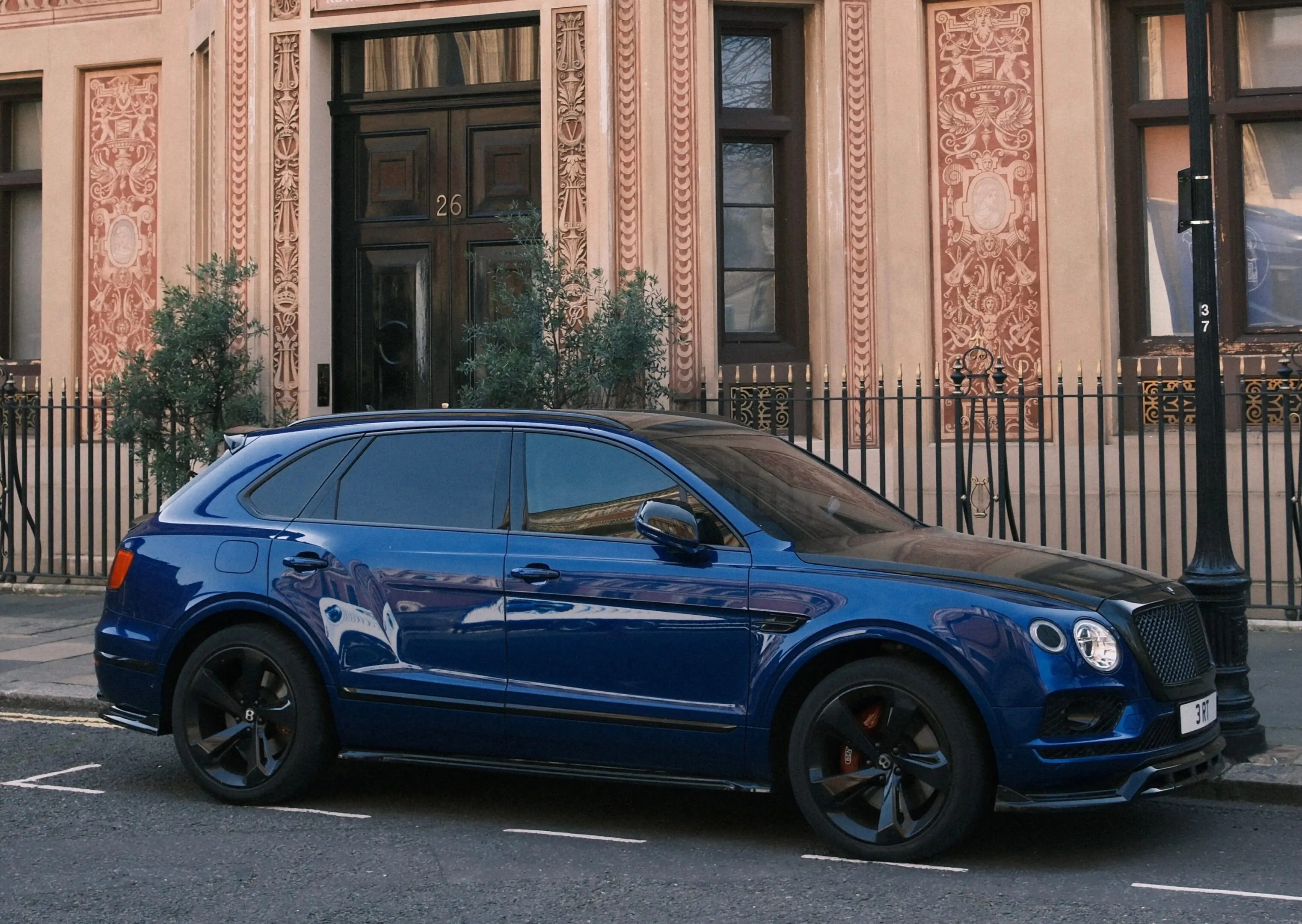 Blue Bentley SUV by carved stone doorway